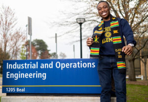 Jeremy Atuobi stands in front of the Industrial Operations and Engineering sign on 1205 Beal Street