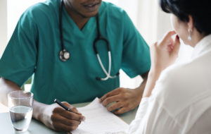 Healthcare worker writes patient details on a piece of paper