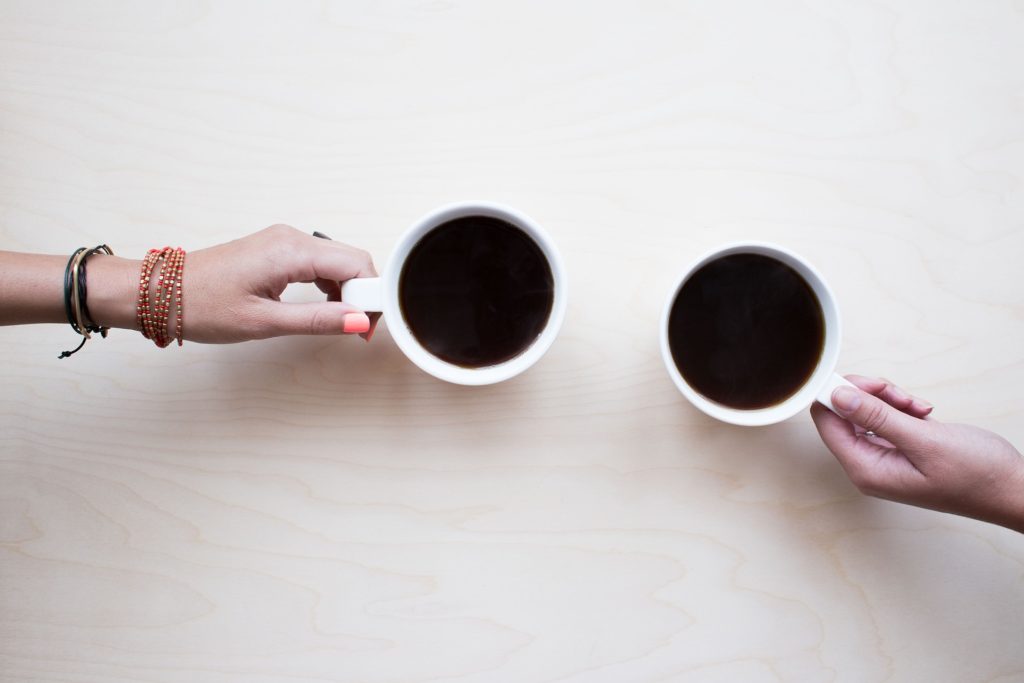 Two people holding coffee cups