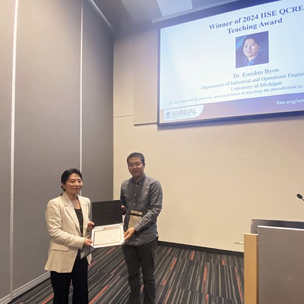 Eunshin being presented with a teaching award at a conference 